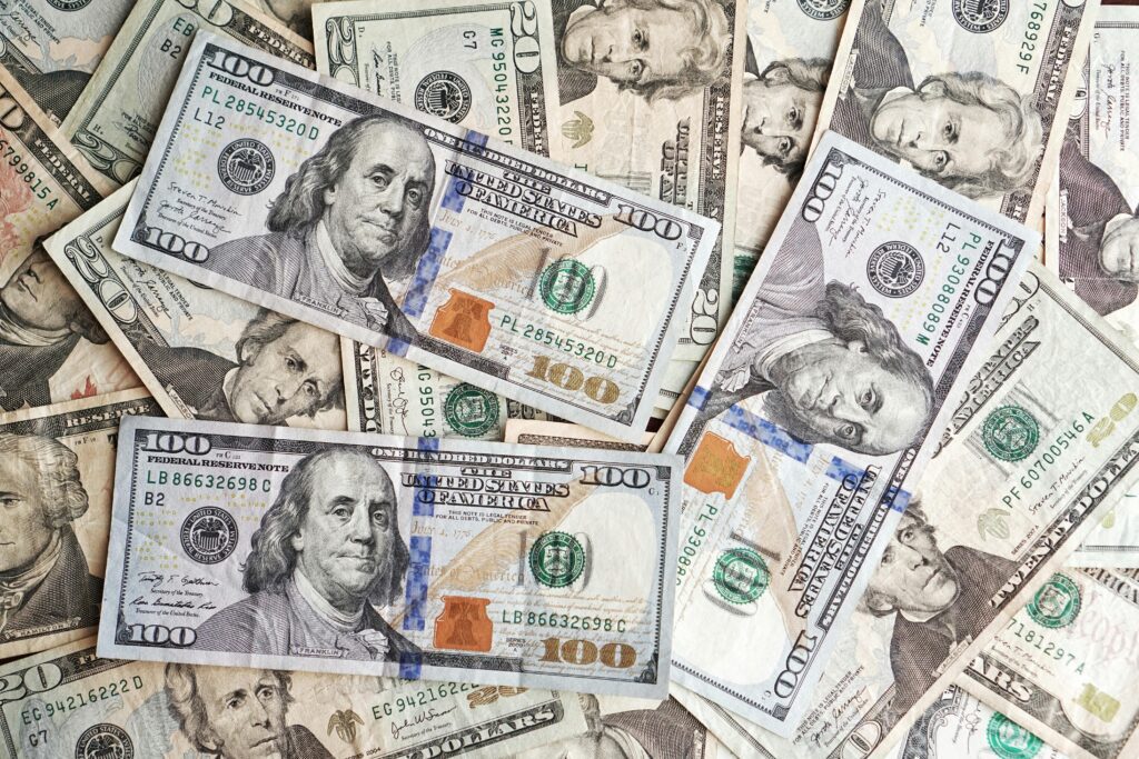 Close-up of various denominations of US dollar banknotes arranged in a pile representing finance and economics.